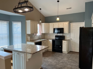 Great house with a corner fireplace that can be viewed from the kitchen and the family room.