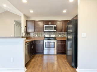Rare Corner Upper Condo with Vaulted Ceilings, Private Balcony and 2 Car Garage - Right Across from the GM Tech Center!