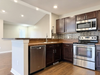 Rare Corner Upper Condo with Vaulted Ceilings, Private Balcony and 2 Car Garage - Right Across from the GM Tech Center!